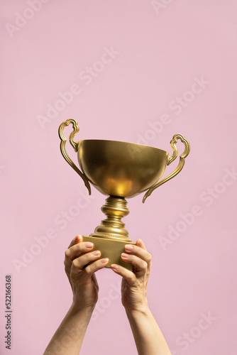 Winner holding golden cup. Success and achievement, victory concept. photo