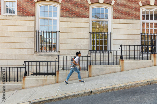 Medium Portrait of Young black student walking on college campus photo