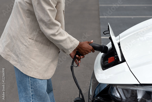 Anonymous black man charging an electric car