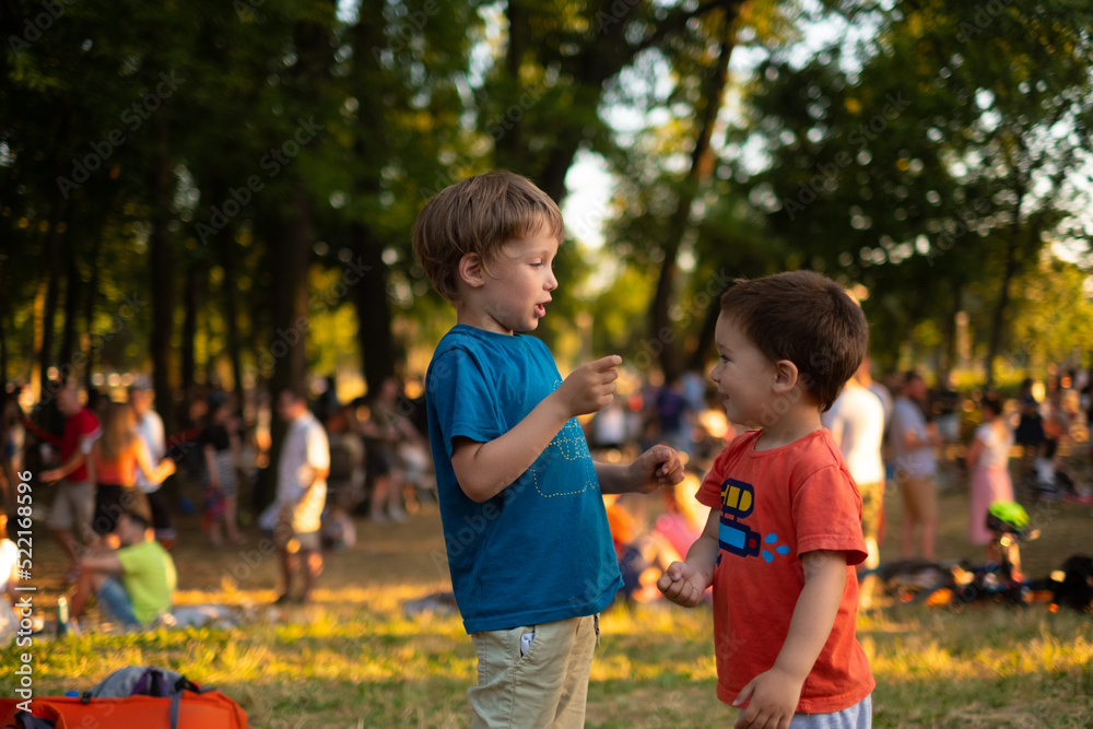 Kids are playing Rock, paper, scissors game in a park full of people