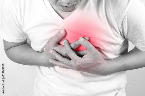 Man is sick and in pain and uses his hands to squeeze his chest He had chest pain caused by an acute heart attack. medical and health concepts