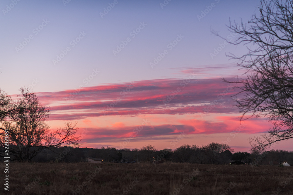 deep pink sunset sky over suburban rural landscape in Texas