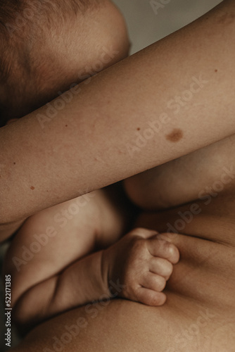 Close Up Vertical photo Of A Baby's Hand stick to the skin of mother photo