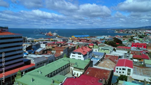 Aerial Shot Of Nautical Vessels At Harbor In Ocean, Drone Flying Forward Over Roofs On Houses - Punta Arenas, Chile photo