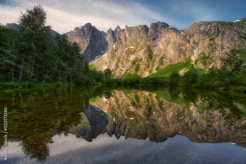 View of the beautiful reflection of the mountain called Troll Wall surrounded by mountains, in central Norway, near the famous Troll Ladder road
