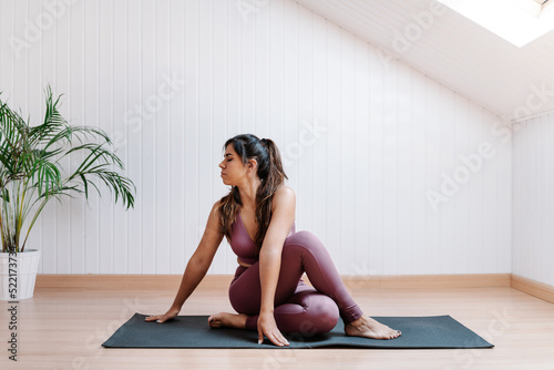 Young woman practicing yoga in twist pose