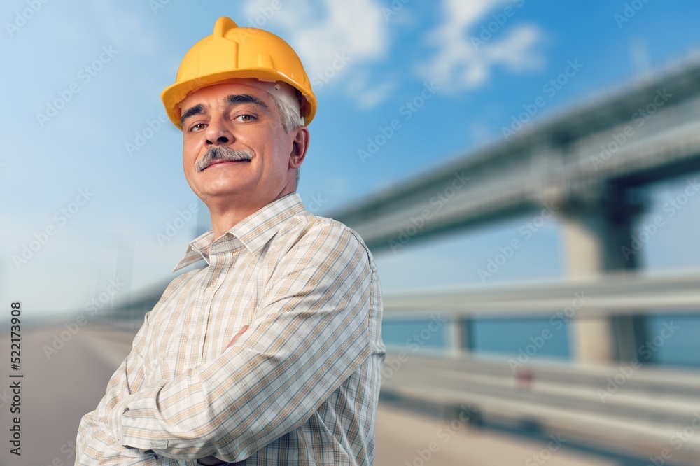 An engineer handsome man or architect looking construction with safety helmet in construction site. Standing at highway concrete road site. An engineer handsome man or architect looking construction with safety helmet in construction site. Standing at highway concrete road site.