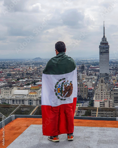 Mexican with a flag in a building 