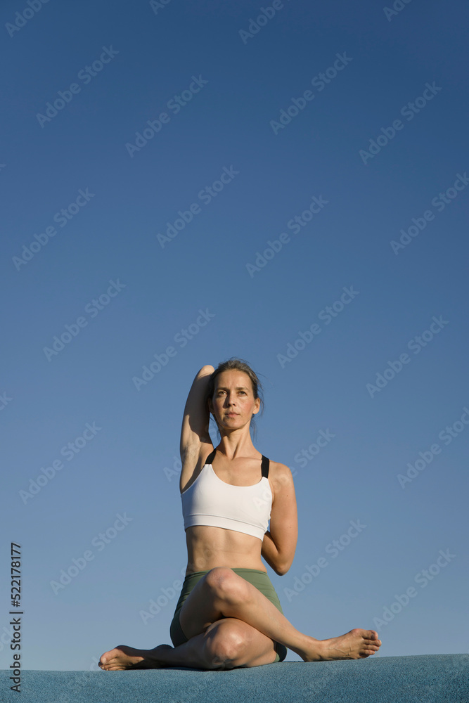 Woman doing the cow face pose outdoor Woman doing the cow face pose outdoor