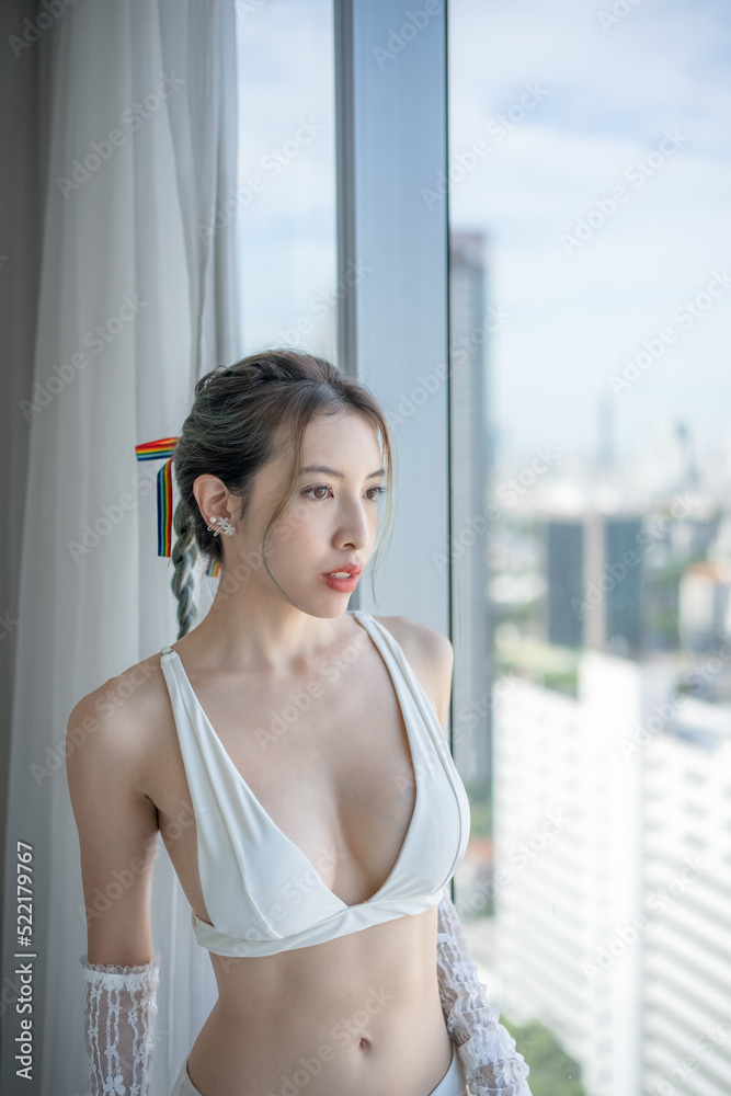 Portrait woman posing in underwear on her balcony with city view. Portrait woman posing in underwear on her balcony with city view.