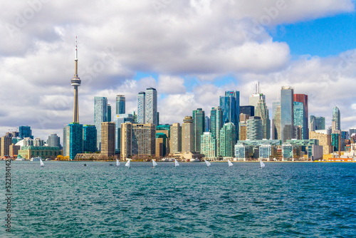 Toronto City Skyline with Famous CN Tower View from Lake Ontario under Bright Cloudy Sky, Ontario, Canada - Panoramic Urban Architecture and Downtown Waterfront View on Clear Summer Day Background