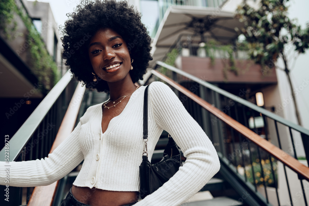 Young smiling african woman poses near stairs in the city Stock Photo ...