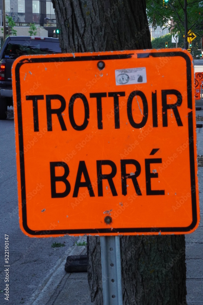Fototapeta premium Montreal, Quebec, Canada - 06-22-2022 : Sidewalk blocked written in French