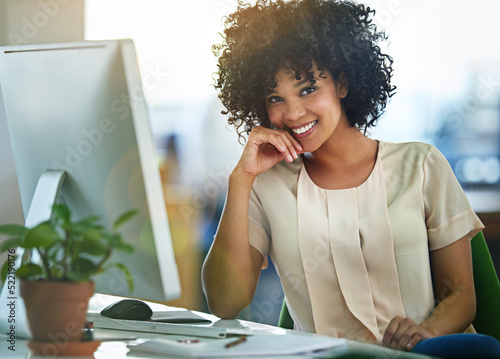Canvas Print Successful, happy and confident business woman sitting at computer at desk with a positive mindset