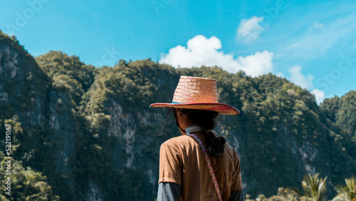 Cowgirl in the mountains. Asian girl standing looking up hill view and blue sky and copy space. Young girl love wild life, travel, freedom. Happy traveler in asia