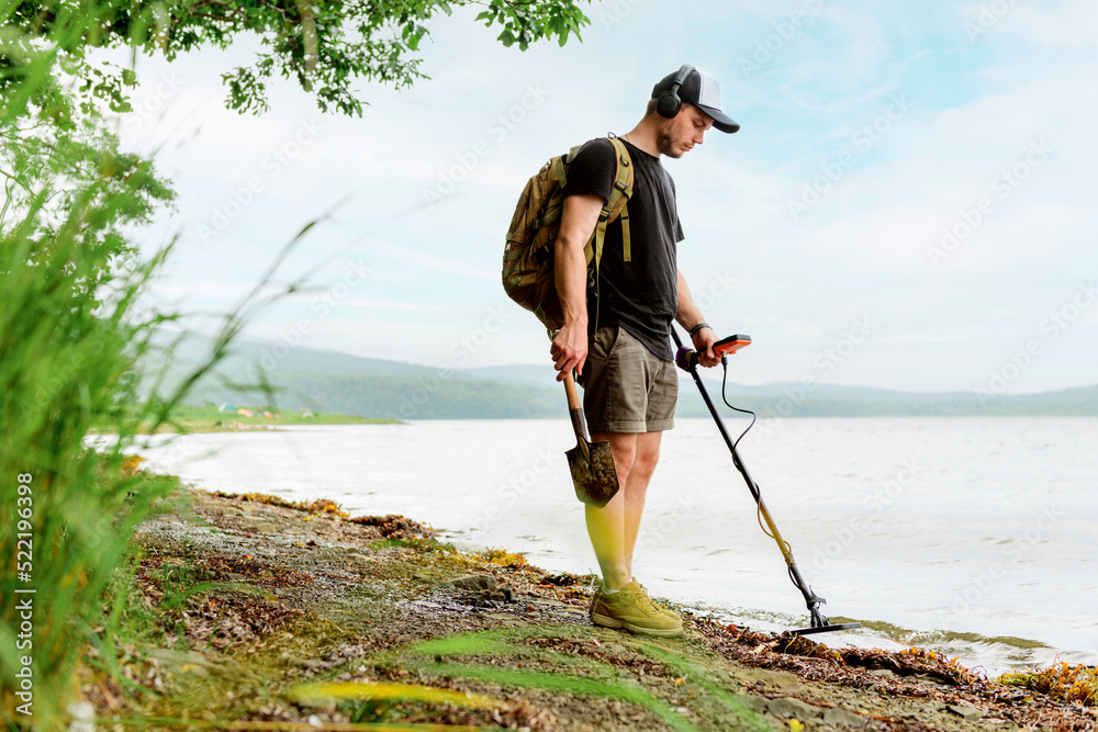 metal detector at work in the forest or field. Search for treasure and ...