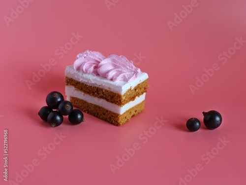 Puff pastry with pink cream and black currant berries on a pink background. Confectionery