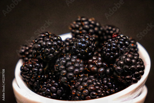A lot of juicy blackberries lie on a plate
