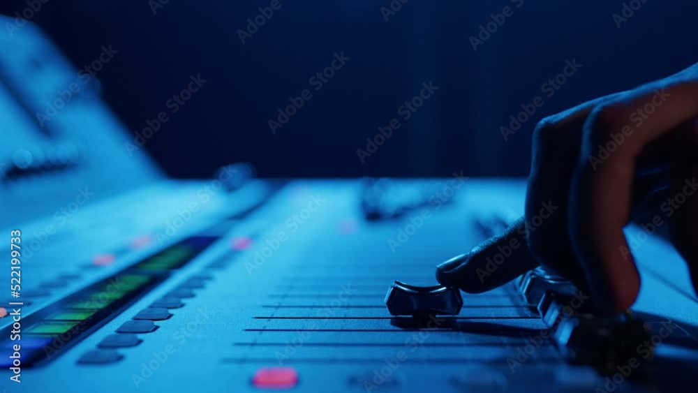 Close-up of the hands of a male DJ who controls the sound on a professional controller