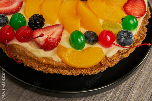 fruitcake with strawberries, blueberries, cherries and peaches close-up view