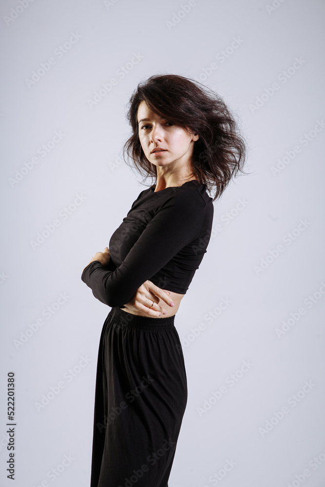 emotional beautiful girl in black clothes on a gray background emotional beautiful girl in black clothes on a gray background