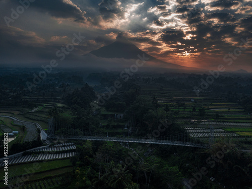 Aerial view of Mount Merapi sunrise with Mangunsuko bridge with dramatic sunrise sky photo