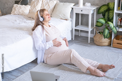 pregnant woman with big belly advanced pregnancy in wireless headphone listening music