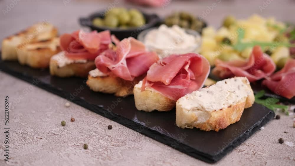 Making bruschetta with prosciutto or jamon ham at domestic kitchen Making bruschetta with prosciutto or jamon ham at domestic kitchen