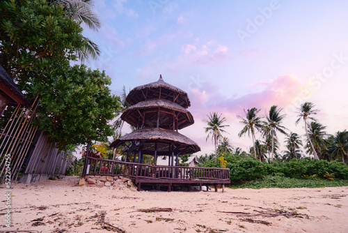 Tropical landscape with wooden bungalow on sand beach. © luengo_ua