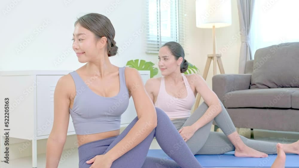 Asian people practicing yoga lifestyle class on a mat at living room ...
