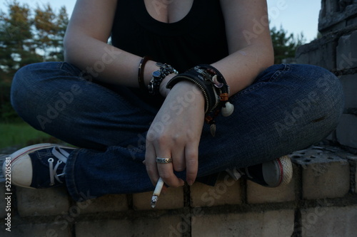 person with a cigarette sitting on crossed legs
