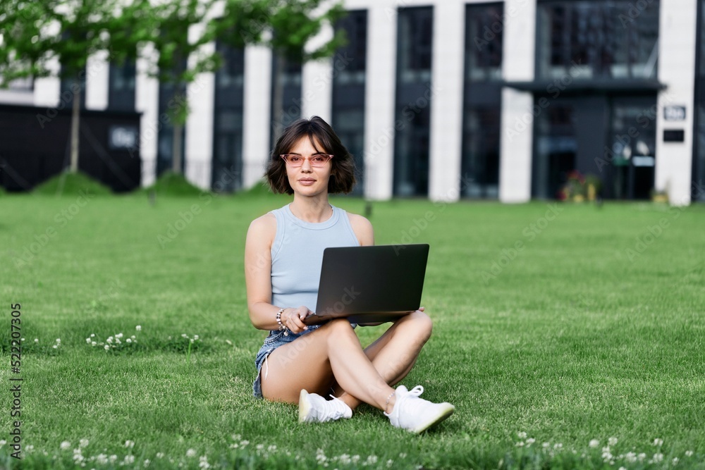 Beautiful smiling girl working with laptop in the park Beautiful smiling girl working with laptop in the park