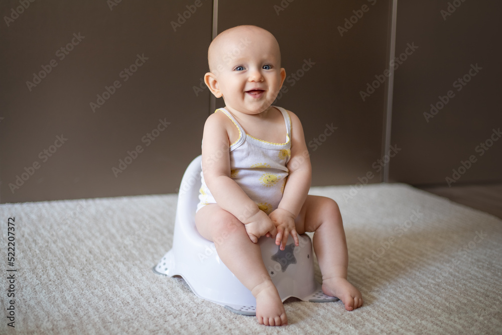 Cute baby in a diaper sitting on a potty. Toilet and potty training. A