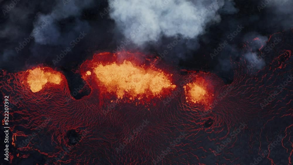 Top down view of active fissure volcano with hot molten lava spewing on earth surface