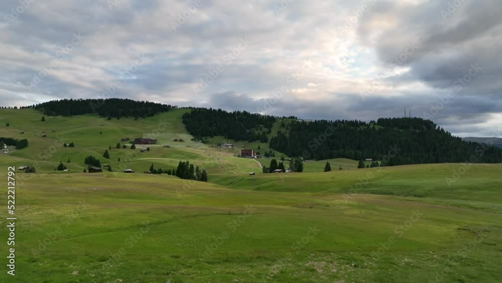 Amazing view on Dolomites peak with a hiking path leading to the mountains. Sunrise drone shot of idyllic Alpe di Suisi mountains in South Tyrol. Wooden cottages at sunrise. Amazing view on Dolomites peak with a hiking path leading to the mountains. Sunrise drone shot of idyllic Alpe di Suisi mountains in South Tyrol. Wooden cottages at sunrise.