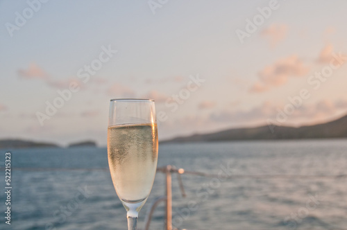 Bubby sparkling champagne flute glass with evening scene while sailing in the Pacific Ocean in Queensland Australia