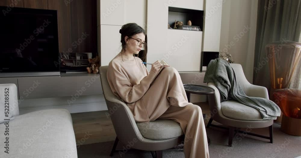 Attractive Woman freelance writer is writing his article on a notebook. idea and inspiration concept. Businesswoman writes startup business ideas and plans, creative thoughts to notebook.