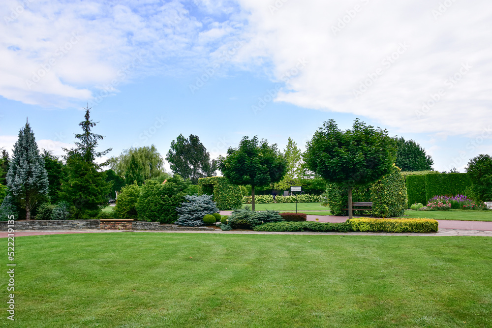 A show garden with grasses, a lake and various decorations in Poland.