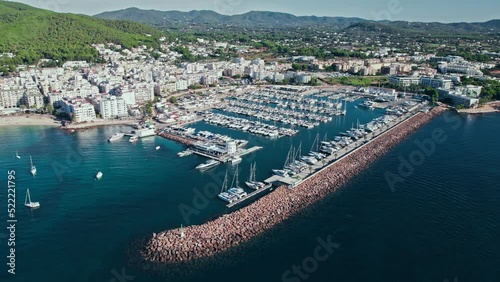 Beautiful view of Port de Santa Eulària des Riu with many vessels in Ibiza. Aerial view of Playa De Santa Eulalia beach by the harbour with coastal resorts and hotels on Balearic Islands, Spain. photo