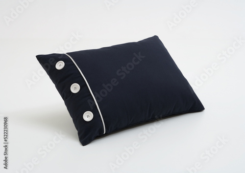 Dark blue pillow with three white button , white background , isolated.