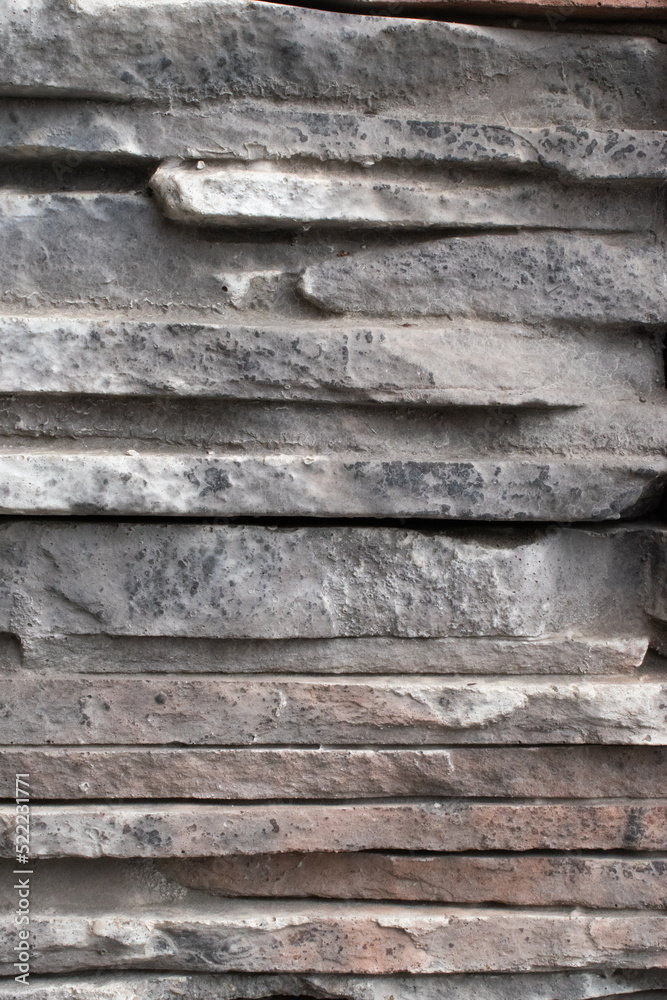 Texture of tiles and flat gray stones stacked on top of each other. Art trim on the wall of the house. Texture of tiles and flat gray stones stacked on top of each other. Art trim on the wall of the house.