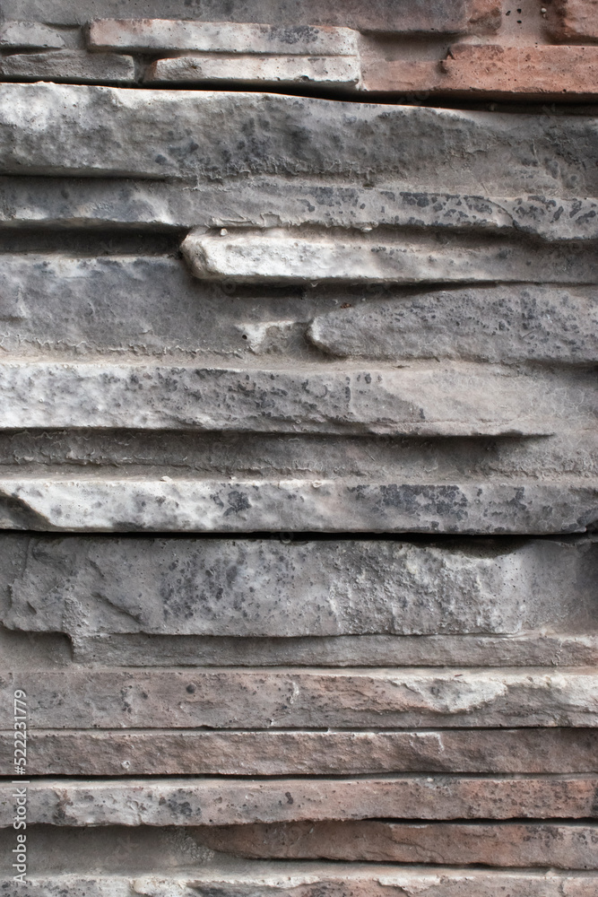 Texture of tiles and flat gray stones stacked on top of each other. Art trim on the wall of the house. Texture of tiles and flat gray stones stacked on top of each other. Art trim on the wall of the house.