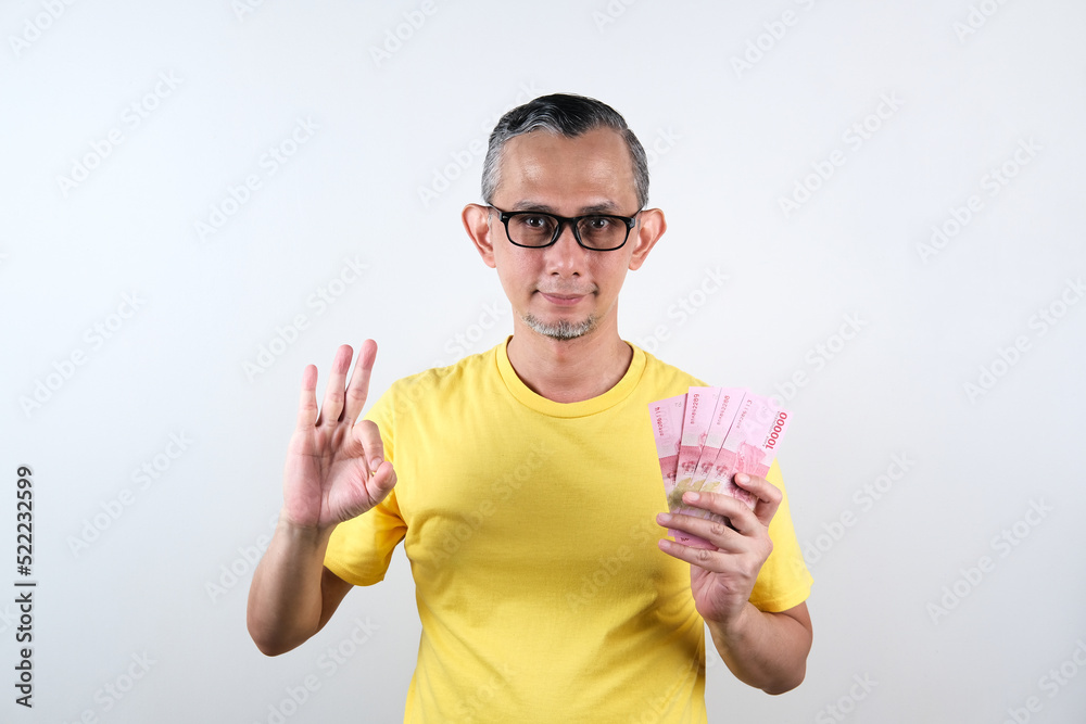 Portrait of Asian Man with casual shirt looking happy with holding lots of money in hand
Portrait of Asian Man with casual shirt looking happy with holding lots of money in hand