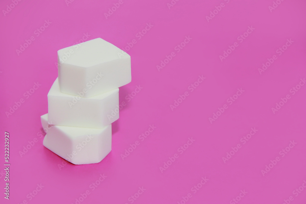 white cosmetic sponges for applying cream on a pink background white cosmetic sponges for applying cream on a pink background