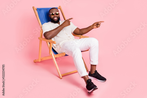 Slika na platnu Full body portrait of cheerful man sit chaise lounge direct fingers empty space