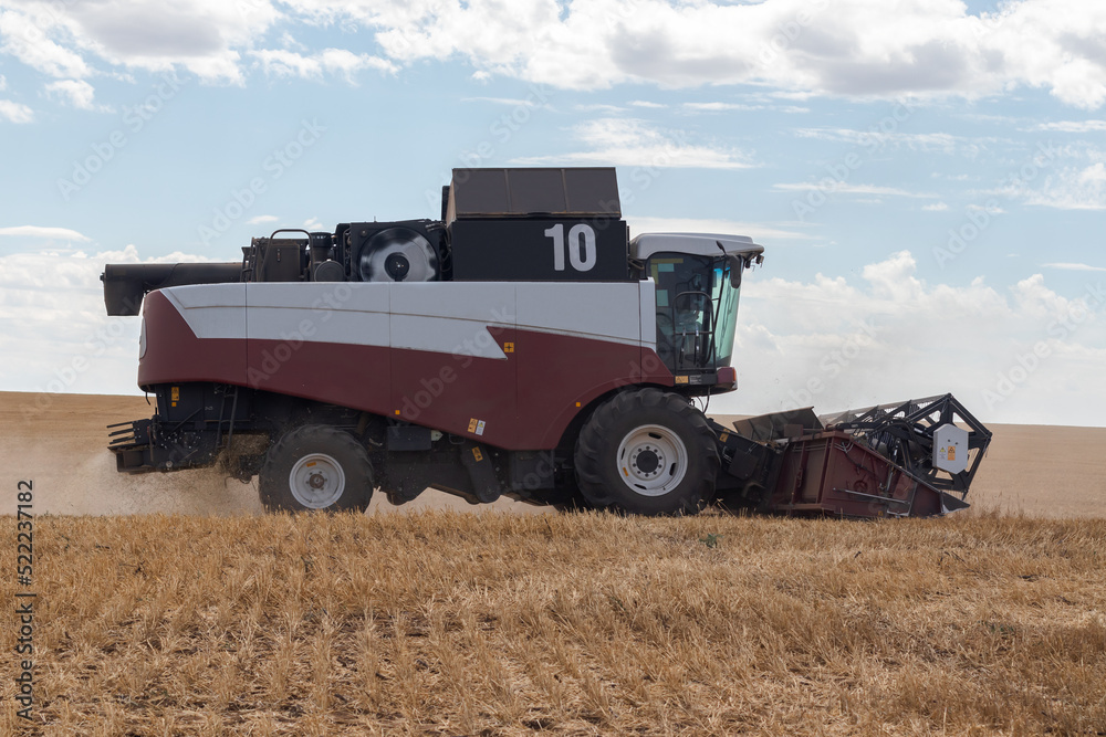 Wheat harvesting in the summer. harvester working in the field Wheat harvesting in the summer. harvester working in the field