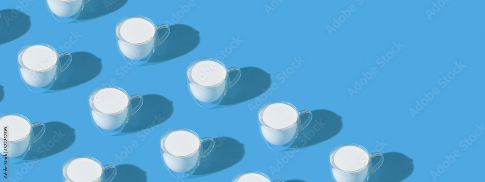 Banner with milk in a glass pattern on blue colored background, dairy diet concept with copy space
