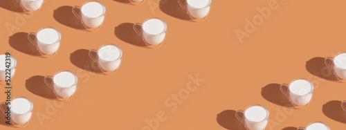 Banner with milk in a glass pattern on orange colored background, dairy diet concept with copy space