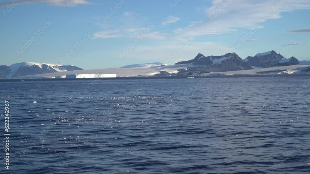 Melting Iceberg with ice floe in foreground, floating in the sea Melting Iceberg with ice floe in foreground, floating in the sea