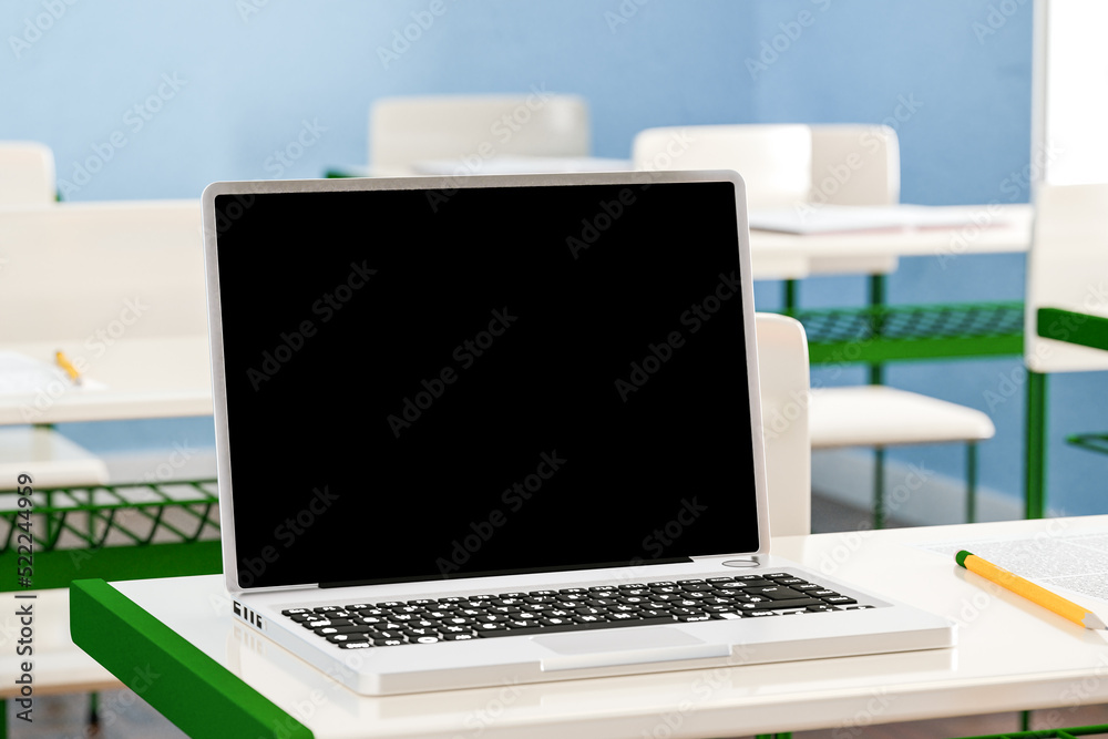 Fototapeta premium Laptop on desk in classroom. 3d render